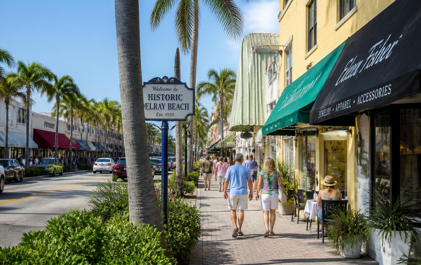 Shoppers walking past storefronts on Atlantic Avenue in historic downtown Delray Beach